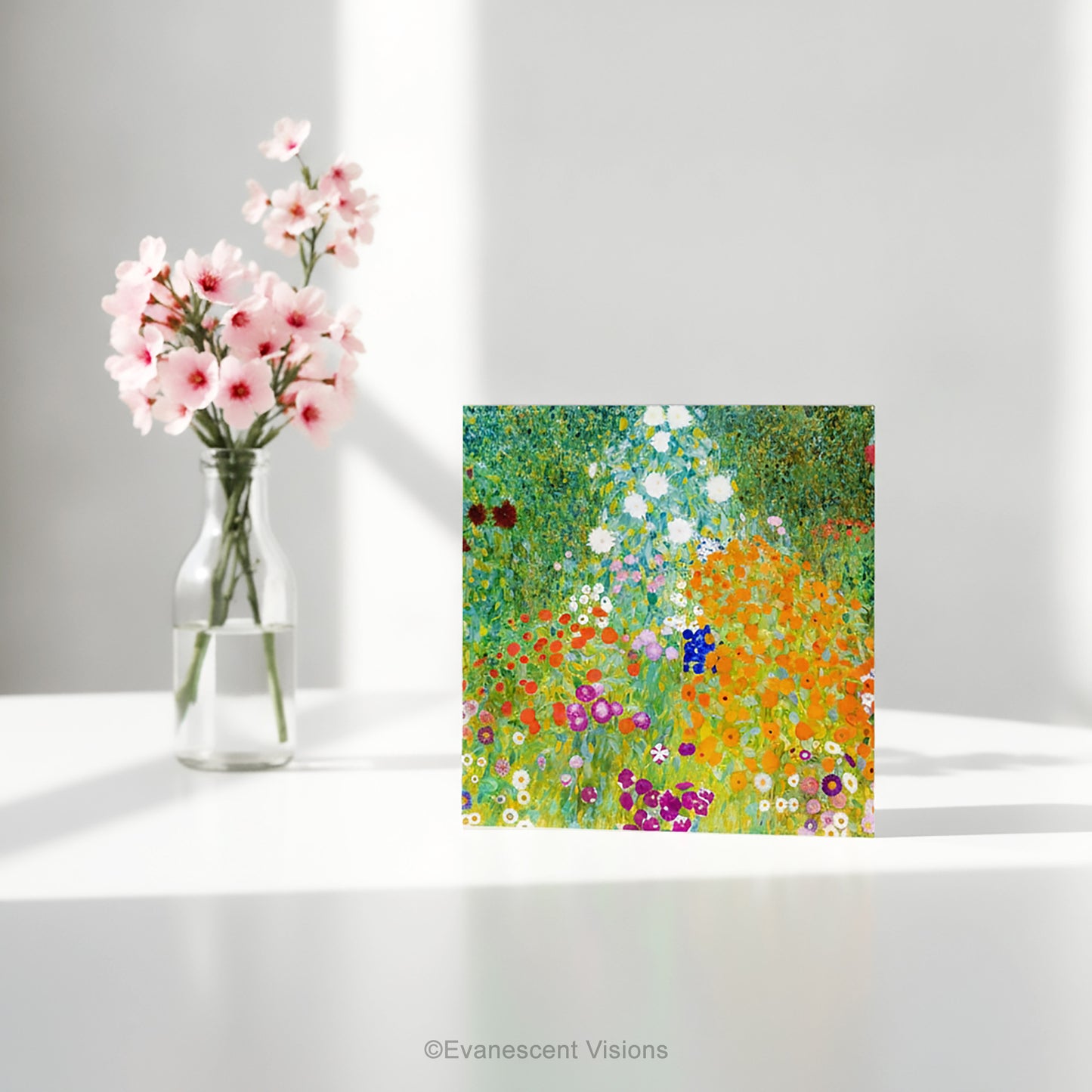 A square art print greeting card with Gustav Klimt arwork 'Bauergarten' a colorful impressionist-style wildflower meadow, standing on a white table with a vase of flowers.