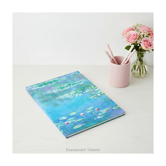 A hardback notebook printed with the impressionist Water Lily painting in blues and greens by artist Claude Monet, shown on a desk top.