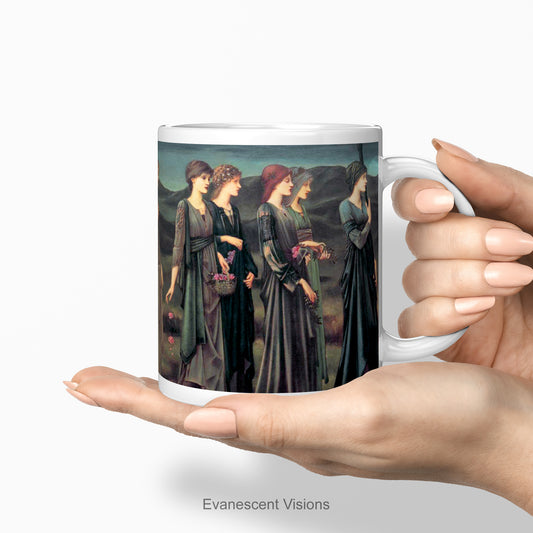 A hand holding a white ceramic mug featuring a print of Burne-Jones painting 'Psyche's Wedding. Wedding'