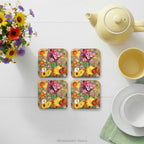 Four square coasters with colourful Wildflowers painting Grand Bouquet de Fleurs de Champs' by Odilon Redon on a table with tableware. 
