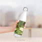 A hand holding the Stainless Steel Water Bottle with the Water Lilies design option