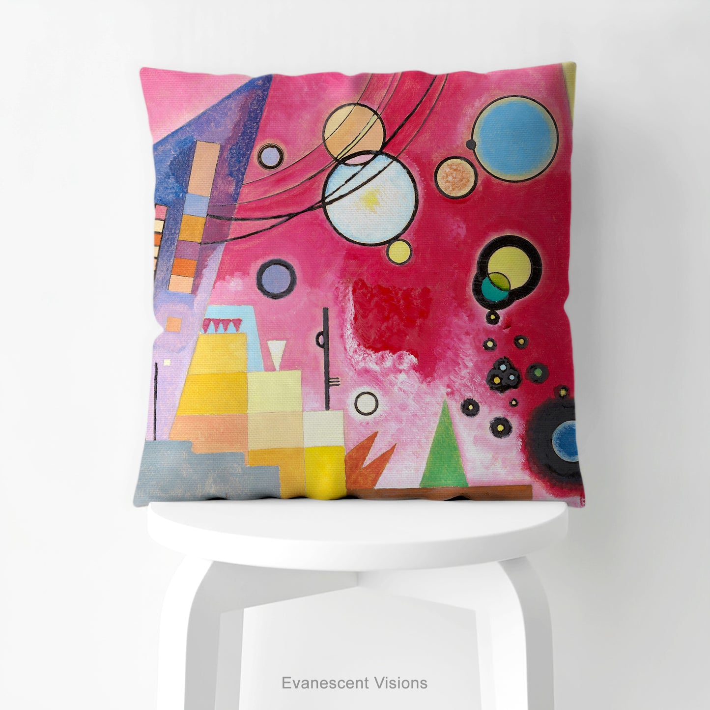 A colourful square cushion on a stool featuring an abstract art print of Schweres Rot (Heavy Red) by abstract artist Wassily Kandinsky.
