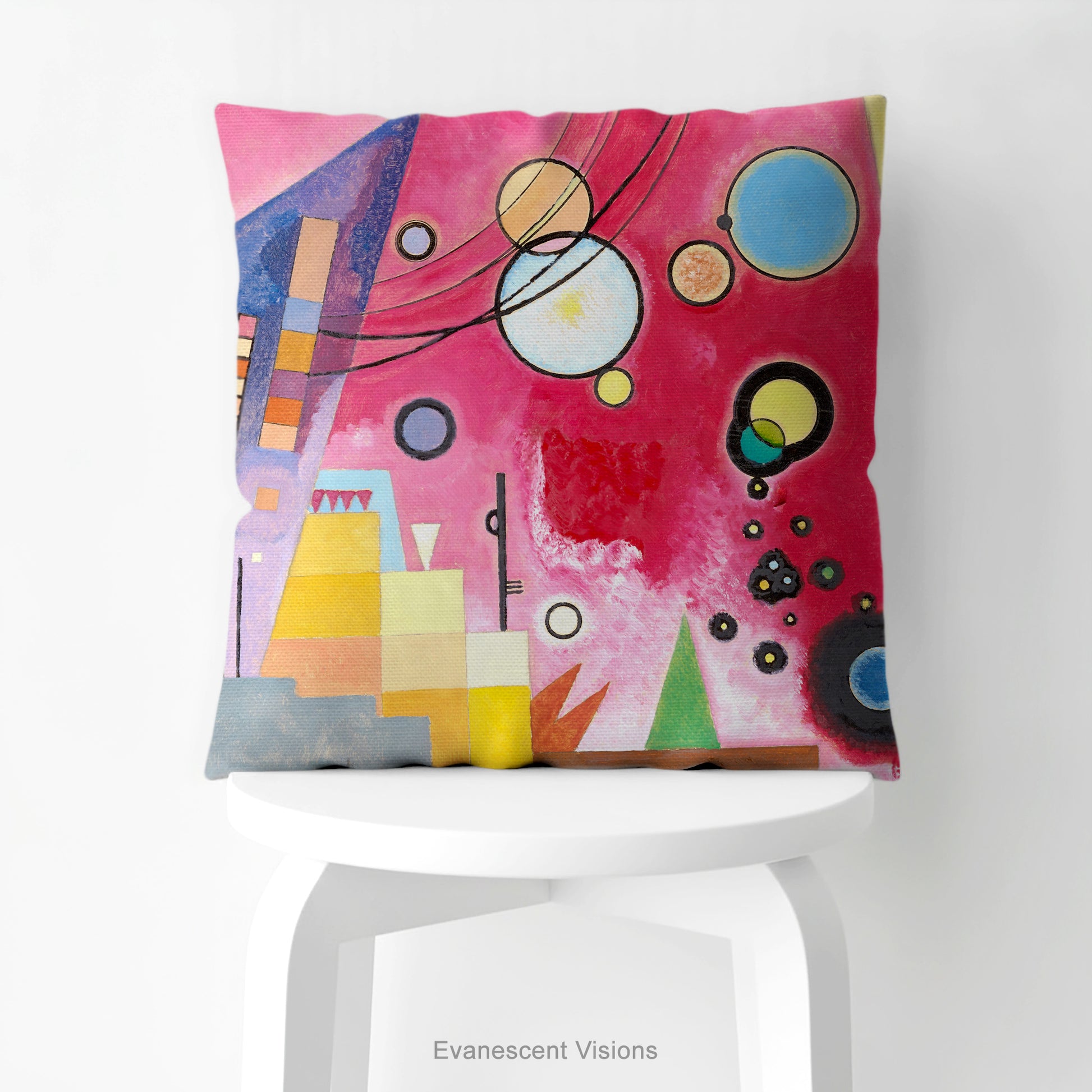 A colourful square cushion on a stool featuring an abstract art print of Schweres Rot (Heavy Red) by abstract artist Wassily Kandinsky.