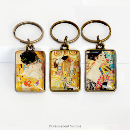 Three keychains with artistic designs by Gustav Klimt on a white background