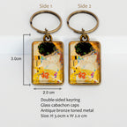 Two keychains with artistic design The Kiss by Gustav Klimt, labeled 'Side 1' and 'Side 2', on a white background with product details
