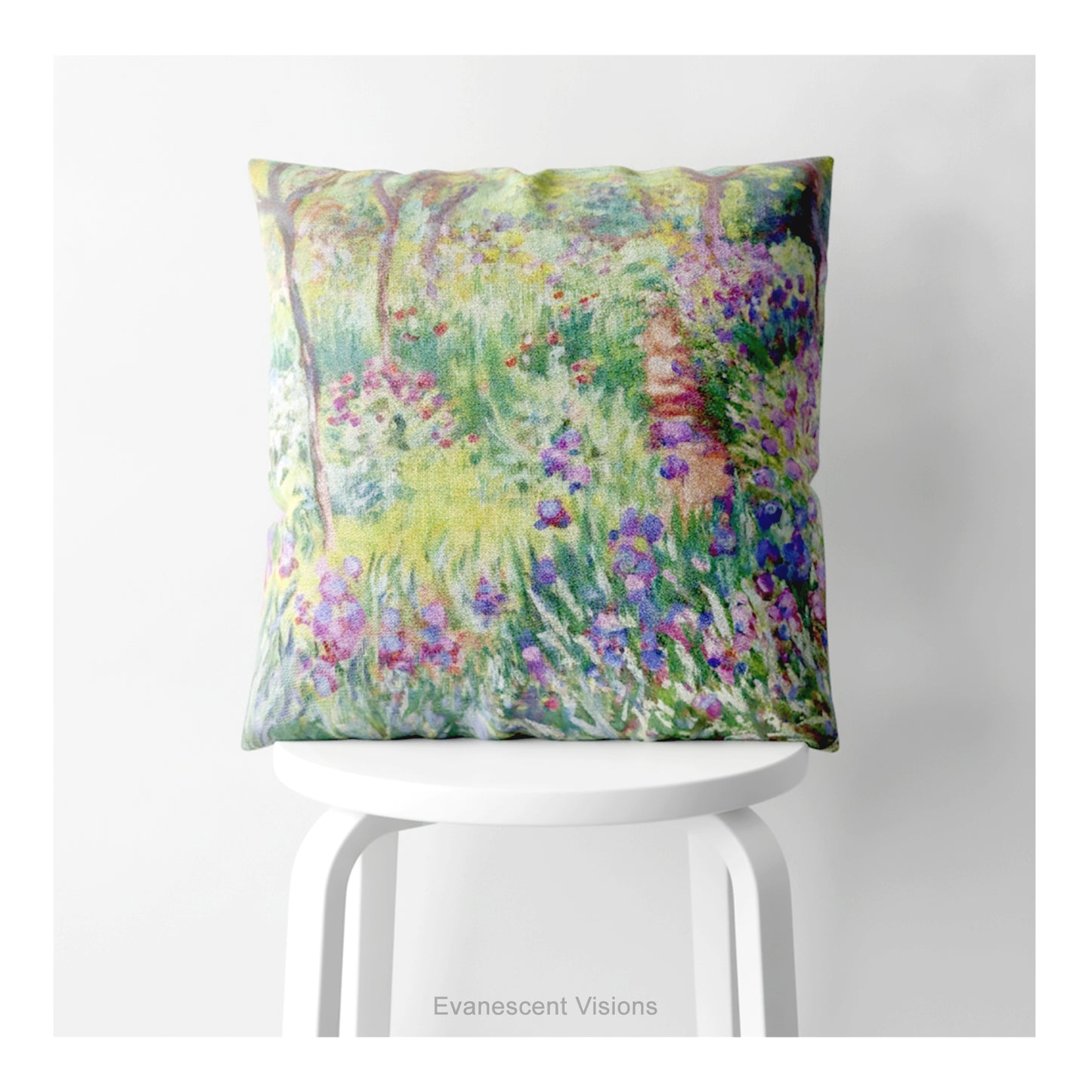 A square decorative cushion on a white stool featuring an impressionist floral artwork 'The Artist's Garden' by Claude Monet.
