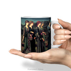 A hand holds a white ceramic mug featuring a print of Burne-Jones painting 'Psyche's Wedding, 