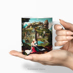 Hand holding a ceramic mug with print of 16th century biblical painting of  Mary and Jesus on the flight into Egypt. 