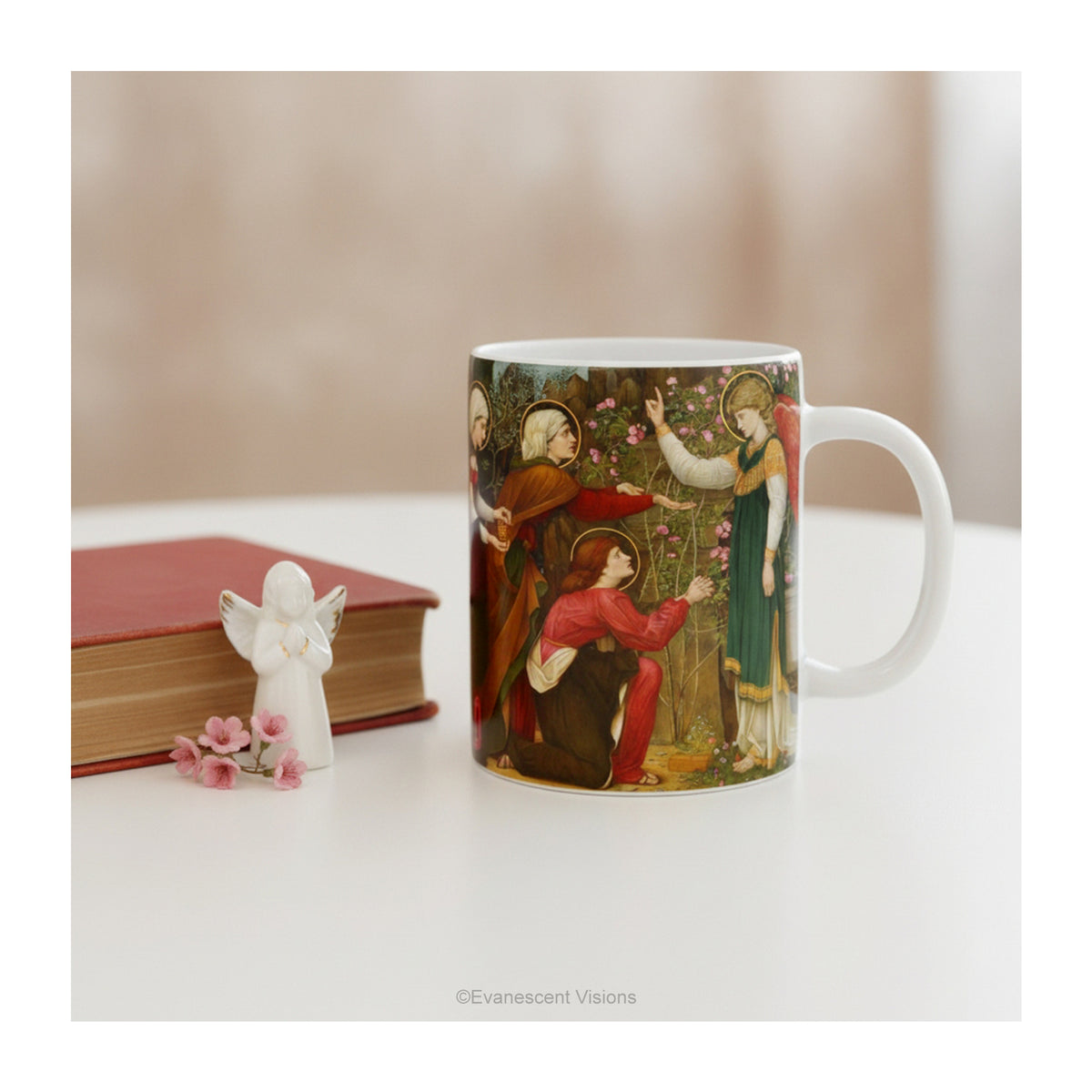 Ceramic mug with artwork depicting the Three Mary's with an Angel, styled on a table.