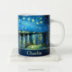Ceramic mug with Van Gogh's painting Starry Night Over the Rhône, in blue and yellow tones, with a personalised name below. 