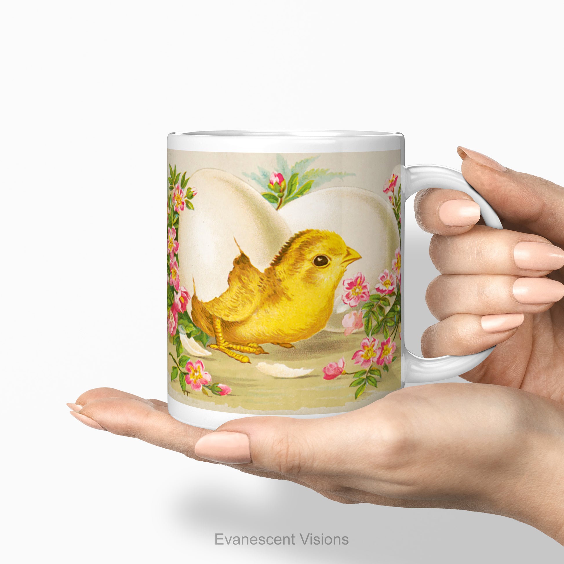 Mug with design of Easter Chick breaking out of an egg surrounded by pink flowers being held in female hands.