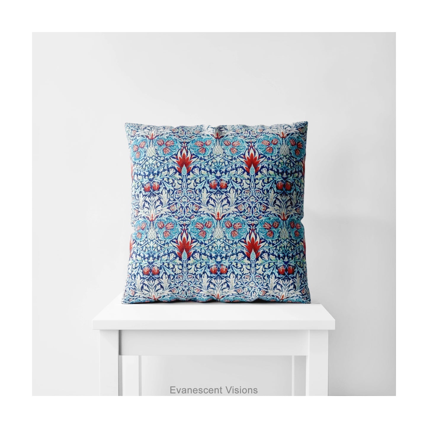 A square decorative cushion with red and blue floral  themed pattern entitled 'Snakeshead' by William Morris, on a white stool. 