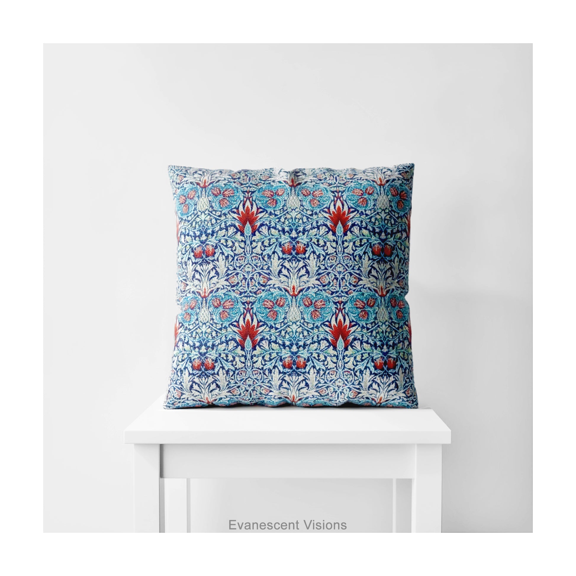 A square decorative cushion with red and blue floral  themed pattern entitled 'Snakeshead' by William Morris, on a white stool. 