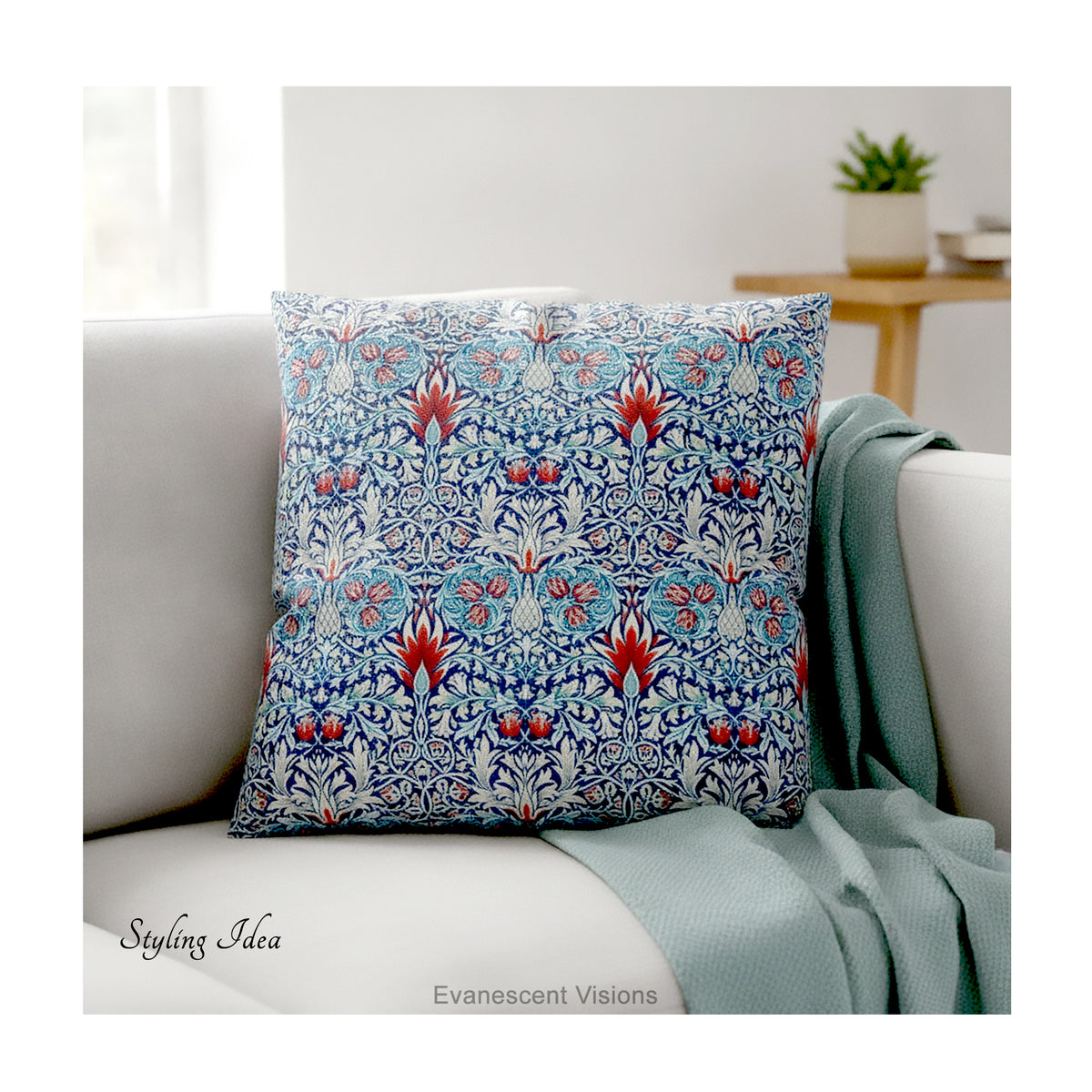 A square decorative cushion with red and blue floral  themed pattern entitled 'Snakeshead' by William Morris, on cream coloured sofa