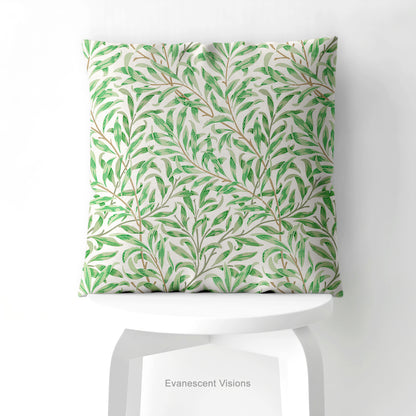 A square decorative cushion with green botanical pattern titled 'Willow Bough' by William Morris, on a white stool