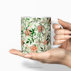 Hands holding a ceramic mug featuring botanical pattern  'Jasmin'  by William Morris.