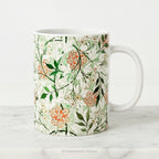 A ceramic mug featuring botanical pattern  'Jasmin'  by William Morris. on a white background.
