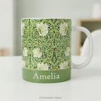 Ceramic mug with William Morris's 'Pimpernel' floral design and personalisation, styled on a table. 