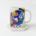A white ceramic mug featuring an abstract geometric artwork 'Jaune Rouge Bleu' by Wassily Kandinsky.